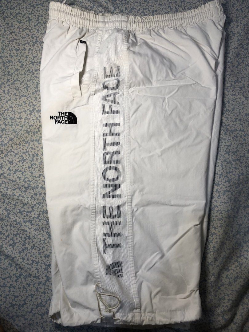 The North Face White Side Striped 3/4s (Category: Joggers) located in Caloocan City. Submitted by castroemman0201 (Listing ID 1467675308, Image 1). Description: - Brand: The North Face - Size: Tagged 105 - Color: White - Fit: Elastic waistband with adjustable drawstring hem at the bottom - Details: Bold mesh side panels with The North Face branding and embroidered logo near the front pocket - Pockets: Convenient zip pocket on the side with a bran