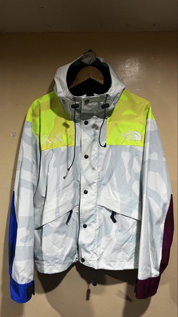 The North Face x KAWS Retro 1994 Mountain Light Jacket (Category: Coats, Jackets and Outerwear) located in Tacloban City. Submitted by rxluminoque (Listing ID 1467723155, Image 1). Description: - Authentic The North Face x KAWS collaboration jacket - Eye-catching multi-color print with neon yellow shoulders - Contrasting blue and maroon sleeve cuffs - Hooded design with adjustable drawstrings and snap button front closure - Size: US Small / Asia 