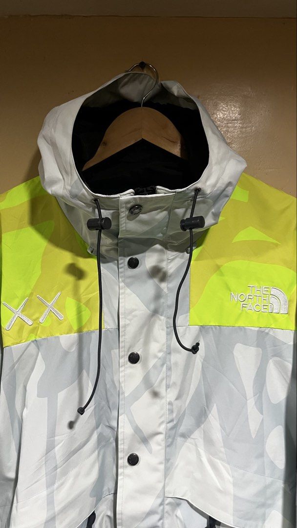 The North Face x KAWS Retro 1994 Mountain Light Jacket (Category: Coats, Jackets and Outerwear) located in Tacloban City. Submitted by rxluminoque (Listing ID 1467723155, Image 2). Description: - Authentic The North Face x KAWS collaboration jacket - Eye-catching multi-color print with neon yellow shoulders - Contrasting blue and maroon sleeve cuffs - Hooded design with adjustable drawstrings and snap button front closure - Size: US Small / Asia 