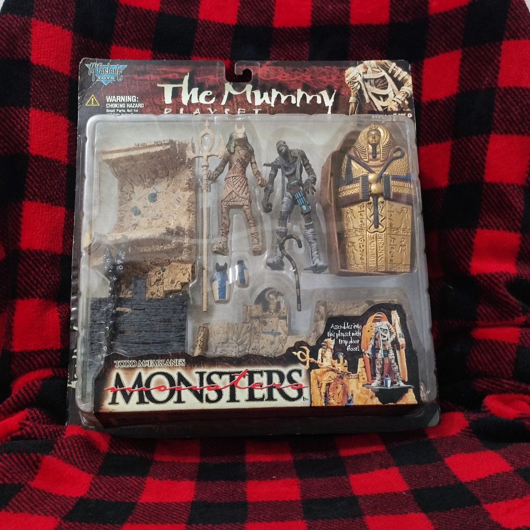 Todd McFarlane Monsters The Mummy Playset (Category: Figurines & Statues) located in Aliaga. Submitted by nekotoys (Listing ID 1467705768, Image 1). Description: - Brand: Todd McFarlane Monsters Series 2 (1998) - Theme: The Mummy playset - Condition: Unopened on original blister card with minor shelf wear - Includes: Anubis figure, mummy figure, sarcophagus coffin, and modular ruin diorama pieces - Rarity: HTF (Hard to Find) collector's item.