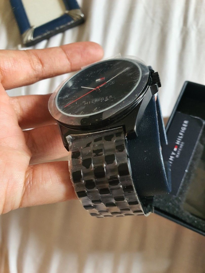 Tommy Hilfiger Men Watch with Box (Category: Men's Watches) located in Paranaque City. Submitted by nicessities (Listing ID 1467650128, Image 2). Description: - Brand: Tommy Hilfiger - Colorway: black - Design: Round dark dial with minimalist markers and a red second hand - Condition: Brand new, metal link strap still wrapped in protective plastic film - Inclusions: Original branded presentation box and store tag with barcode - Ideal for: Casual 