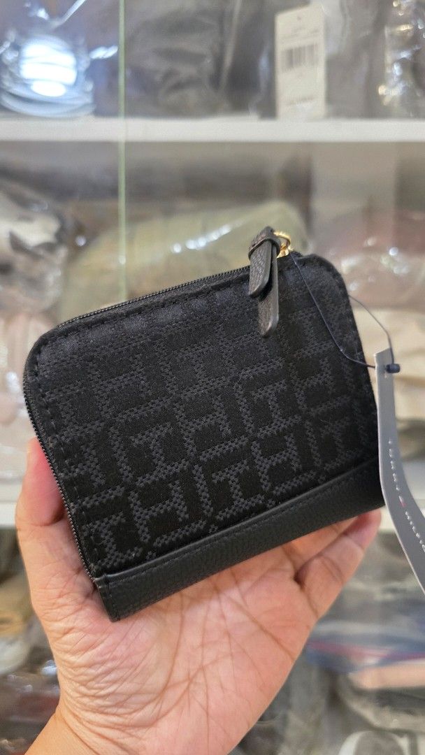 Tommy Hilfiger Monogram Small Black Wallet (Category: Wallets & Card holders) located in Quezon City. Submitted by momof3_11 (Listing ID 1467755514, Image 2). Description: - Brand: Tommy Hilfiger - Color: Classic Black with All-Over Monogram Pattern - Condition: Brand new with tags attached - Closure: Secure snap button closure - Interior: Multiple card slots and a clear ID window - Compartments: Dedicated zippered coin pocket and cash sleeve - D