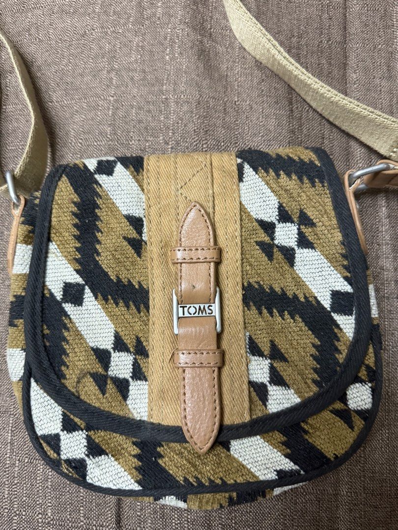 TOMS Aztec Print Crossbody Bag (Category: Cross-body Bags) located in Cainta. Submitted by amswardrobe (Listing ID 1467836630, Image 1). Description: - Brand: TOMS - Style: Crossbody bag with Aztec print in beige, black, and white - Closure: Magnetic snap - Strap: Adjustable for custom comfort - Interior: Includes a handy zippered pocket and the iconic 'This bag helps save a life' patch - Material: Durable canvas and textured fabric exterior with