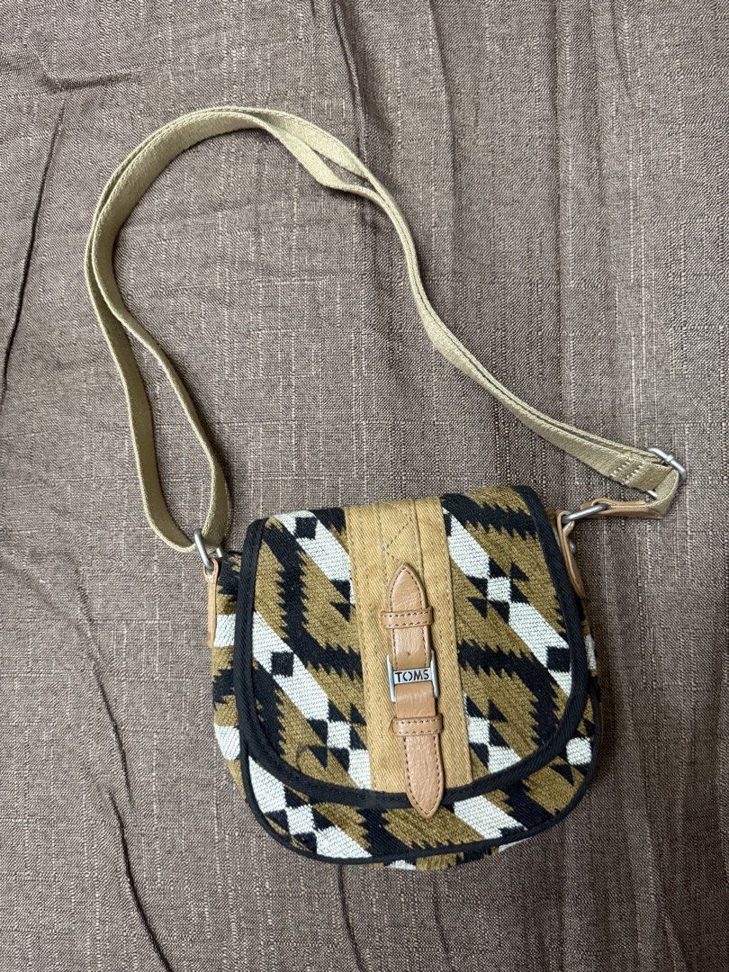 TOMS Aztec Print Crossbody Bag (Category: Cross-body Bags) located in Cainta. Submitted by amswardrobe (Listing ID 1467836630, Image 2). Description: - Brand: TOMS - Style: Crossbody bag with Aztec print in beige, black, and white - Closure: Magnetic snap - Strap: Adjustable for custom comfort - Interior: Includes a handy zippered pocket and the iconic 'This bag helps save a life' patch - Material: Durable canvas and textured fabric exterior with
