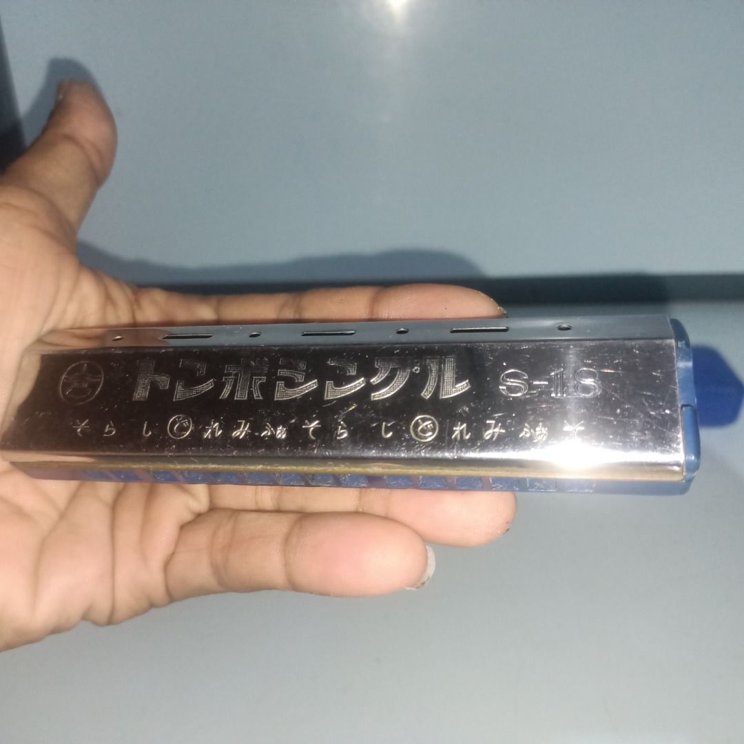 Tonbo Single S-18 Harmonica (Category: Musical Instruments) located in Munoz. Submitted by larryc1212 (Listing ID 1467680871, Image 1). Description: - Model: Tonbo Single S-18 harmonica - Color/Design: Silver metal body with a blue plastic comb and Japanese inscriptions on the cover plate - Type: Standard single-sided layout, made in Japan - Inclusions: Comes with original blue plastic storage case - Condition: Shows minor signs of handling and s