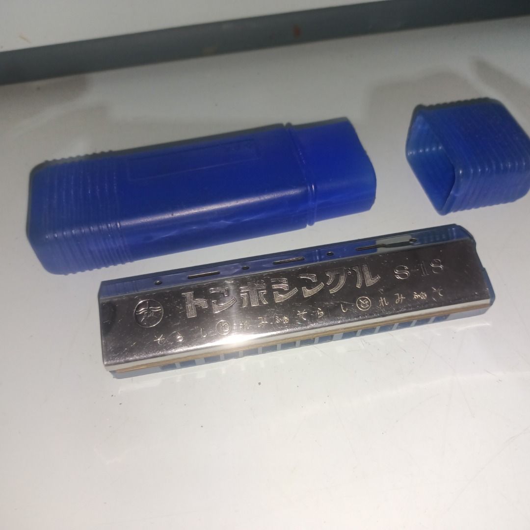Tonbo Single S-18 Harmonica (Category: Musical Instruments) located in Munoz. Submitted by larryc1212 (Listing ID 1467680871, Image 3). Description: - Model: Tonbo Single S-18 harmonica - Color/Design: Silver metal body with a blue plastic comb and Japanese inscriptions on the cover plate - Type: Standard single-sided layout, made in Japan - Inclusions: Comes with original blue plastic storage case - Condition: Shows minor signs of handling and s