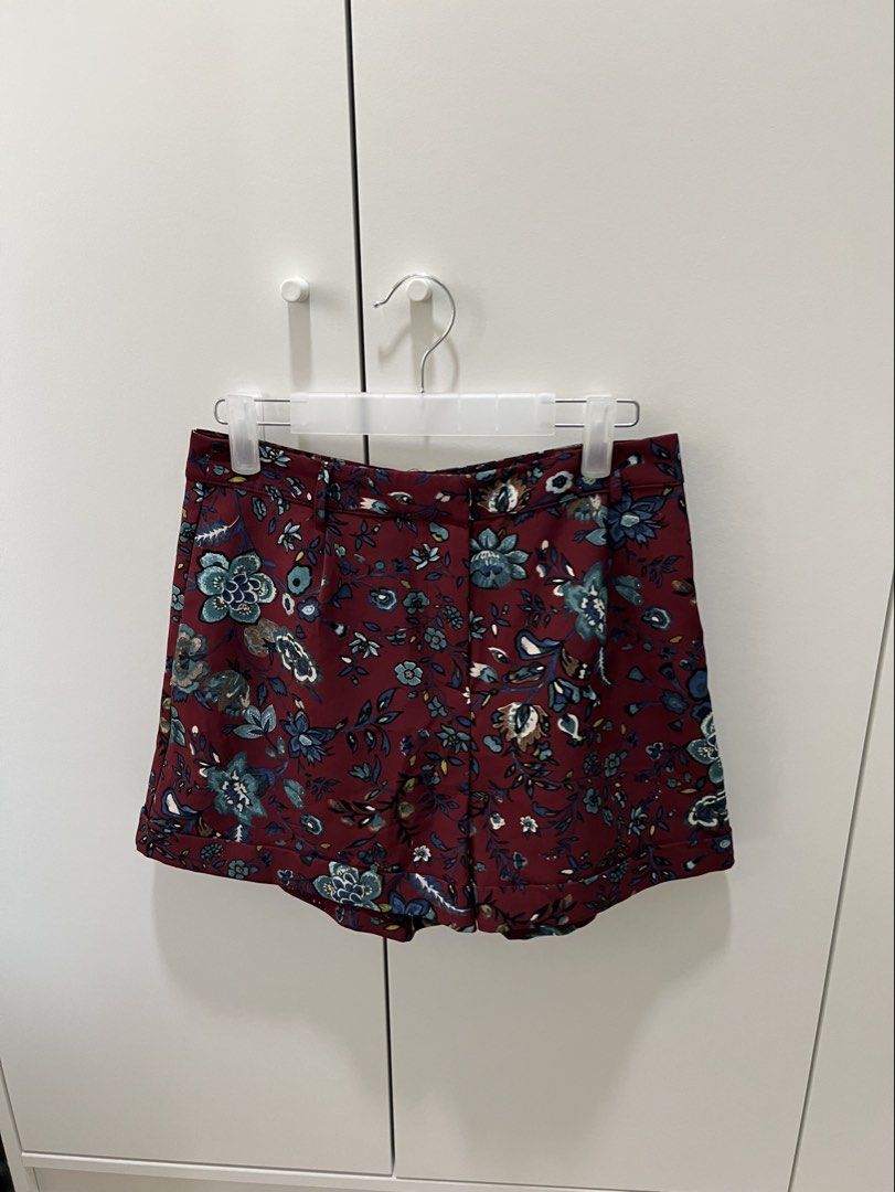 Topshop Maroon Floral Printed Shorts (Category: Shorts) located in Muntinlupa City. Submitted by shopblank (Listing ID 1467753596, Image 2). Description: - Color: Dark red base with blue and green floral print - Fit: Mid-rise waist with belt loops - Details: Chic folded cuffs at the hem - Material: Lightweight and comfortable fabric - Condition: Worn a few times, still in great shape - Care: Clean, washed, and ready to ship.