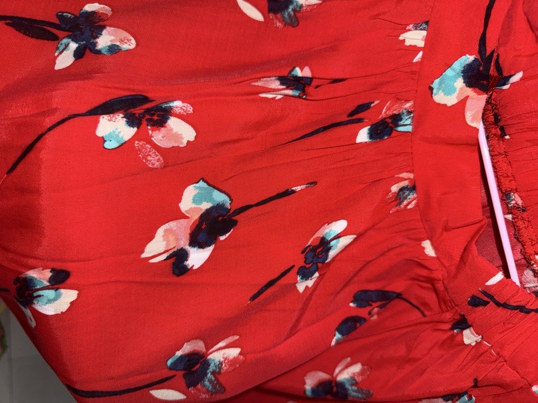 Topshop Red Floral Skirt (Category: Blouses) located in Mandaluyong City. Submitted by declutteringmylife101 (Listing ID 1467681676, Image 2). Description: - Color/Pattern: Bright red with all-over blue and pink floral print - Fit: Short, loose, and easy pullover style - Neckline: Gathered elastic for comfort - Sleeves: Trendy flared design - Fabric: Lightweight and breezy for everyday wear.