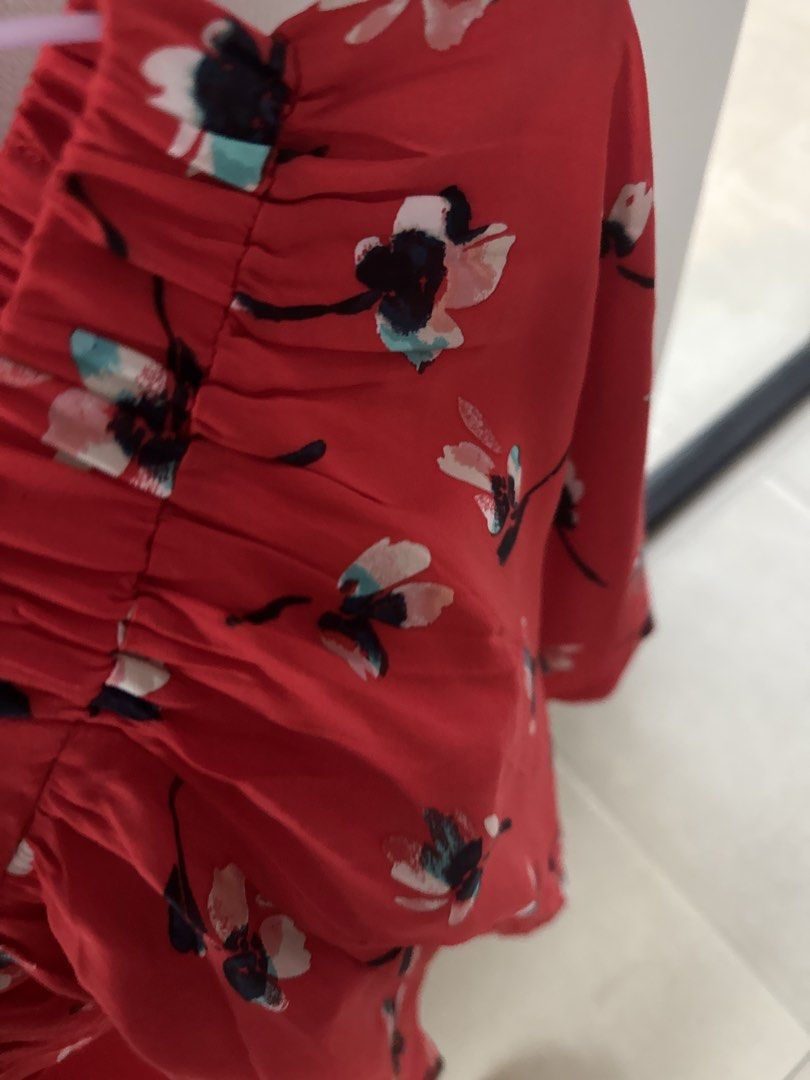 Topshop Red Floral Skirt (Category: Blouses) located in Mandaluyong City. Submitted by declutteringmylife101 (Listing ID 1467681676, Image 3). Description: - Color/Pattern: Bright red with all-over blue and pink floral print - Fit: Short, loose, and easy pullover style - Neckline: Gathered elastic for comfort - Sleeves: Trendy flared design - Fabric: Lightweight and breezy for everyday wear.