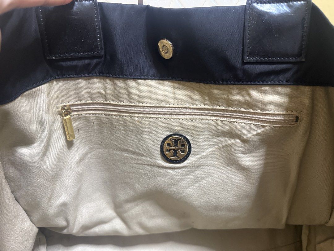 Tory Burch Black Nylon Tote Bag (Category: Tote Bags) located in Tarlac. Submitted by kayeshe (Listing ID 1467740073, Image 3). Description: - 100% authentic - Material: Durable black nylon with patent leather trim and handles - Features: Large patent leather front logo, magnetic top snap closure - Interior: Beige fabric lining with a zippered pocket and metal logo plaque - Condition: Roomy everyday bag with minor wear on patent trim corners.
