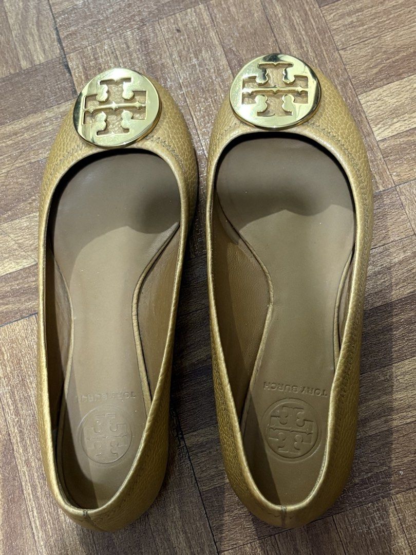 Tory Burch Gold Leather Ballet Flats (Category: Flats & Sandals) located in Manila. Submitted by nykji96 (Listing ID 1467830724, Image 1). Description: - Brand: Tory Burch - Style: Slip-on ballet flats with round toe - Color/Material: Gold textured leather with tan leather lining - Details: Large polished gold logo plaque on vamp - Soles: Textured rubber soles - Condition: Comfort wear with minor signs of handling and slight heel wear - Perfect f