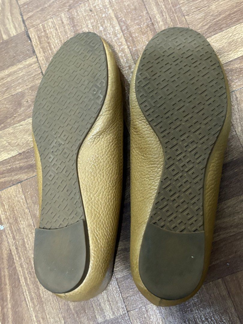 Tory Burch Gold Leather Ballet Flats (Category: Flats & Sandals) located in Manila. Submitted by nykji96 (Listing ID 1467830724, Image 2). Description: - Brand: Tory Burch - Style: Slip-on ballet flats with round toe - Color/Material: Gold textured leather with tan leather lining - Details: Large polished gold logo plaque on vamp - Soles: Textured rubber soles - Condition: Comfort wear with minor signs of handling and slight heel wear - Perfect f
