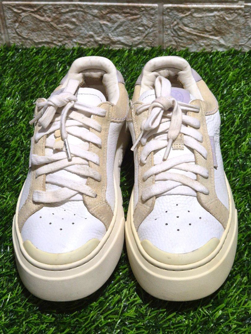 Tory Burch Sneakers White Beige Platform Size: 6.5 (Category: Sneakers) located in Antipolo. Submitted by saribymonica (Listing ID 1461254433, Image 2). Description: - White and beige Tory Burch platform sneakers - Features a lace-up closure - Embossed logo pattern on the platform sole - Minor scuffs on the soles and light creasing on the leather. Shoelace eyelet has a tear damage, as shown in photos..