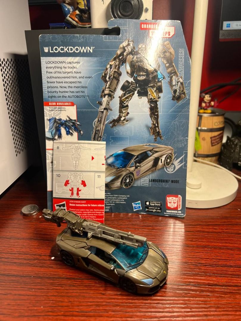 Transformers Age of Extinction Lockdown (Category: Vehicle & Diecast Models) located in Baguio. Submitted by ditoyzb08176 (Listing ID 1467757985, Image 2). Description: - Character: Lockdown from Transformers Age of Extinction - Mode: Transforms into a sleek bronze Lamborghini sports car - Features: Includes large weapon accessory that mounts in vehicle mode and Decepticon logo on the side door - Inclusions: Comes with original instructions and p