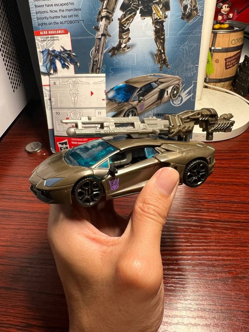 Transformers Age of Extinction Lockdown (Category: Vehicle & Diecast Models) located in Baguio. Submitted by ditoyzb08176 (Listing ID 1467757985, Image 1). Description: - Character: Lockdown from Transformers Age of Extinction - Mode: Transforms into a sleek bronze Lamborghini sports car - Features: Includes large weapon accessory that mounts in vehicle mode and Decepticon logo on the side door - Inclusions: Comes with original instructions and p