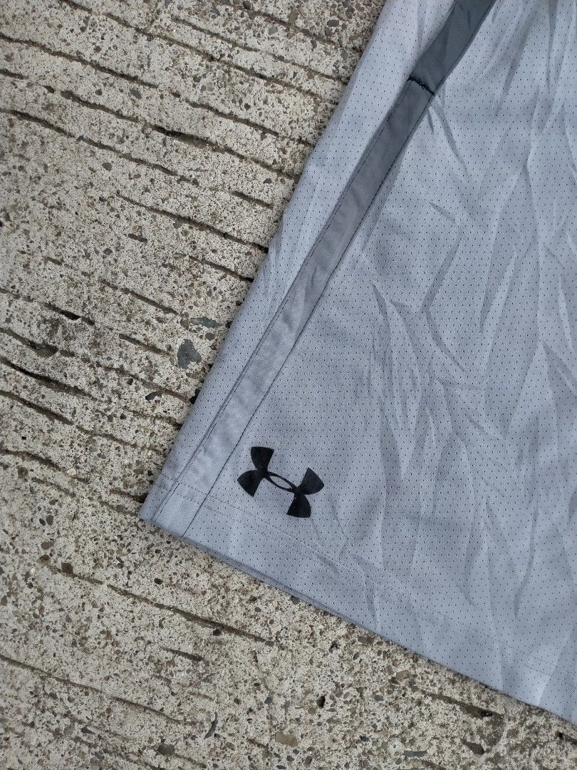 Under Armour Grey Mesh Athletic Shorts Size MD (Category: Shorts) located in Davao. Submitted by ervinpolino09 (Listing ID 1467683734, Image 2). Description: - Brand: Under Armour - Type: Grey mesh athletic shorts - Size: Medium - Fit: Loose fit with elastic waistband and adjustable drawstring - Features: Side pockets and black accent stripes on both legs - Branding: Small black Under Armour logo near bottom hem - Origin: Made in Indonesia.