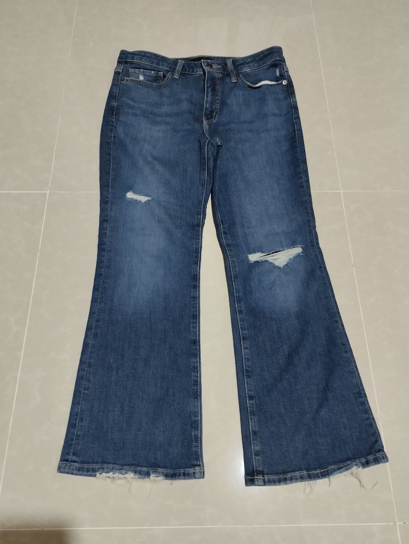 Uniqlo Blue Distressed Flared Jeans (Category: Jeans) located in Mabalacat. Submitted by uniqlover (Listing ID 1467776150, Image 3). Description: - Style: Mid-wash blue denim jeans with a trendy flared leg cut - Details: Distressed knees with a small right thigh rip and larger left knee tear - Hem: Raw, frayed ankle hems for an edgy look - Design: Classic five-pocket styling, belt loops, and front button fly - Fit/Occasion: Casual everyday style,
