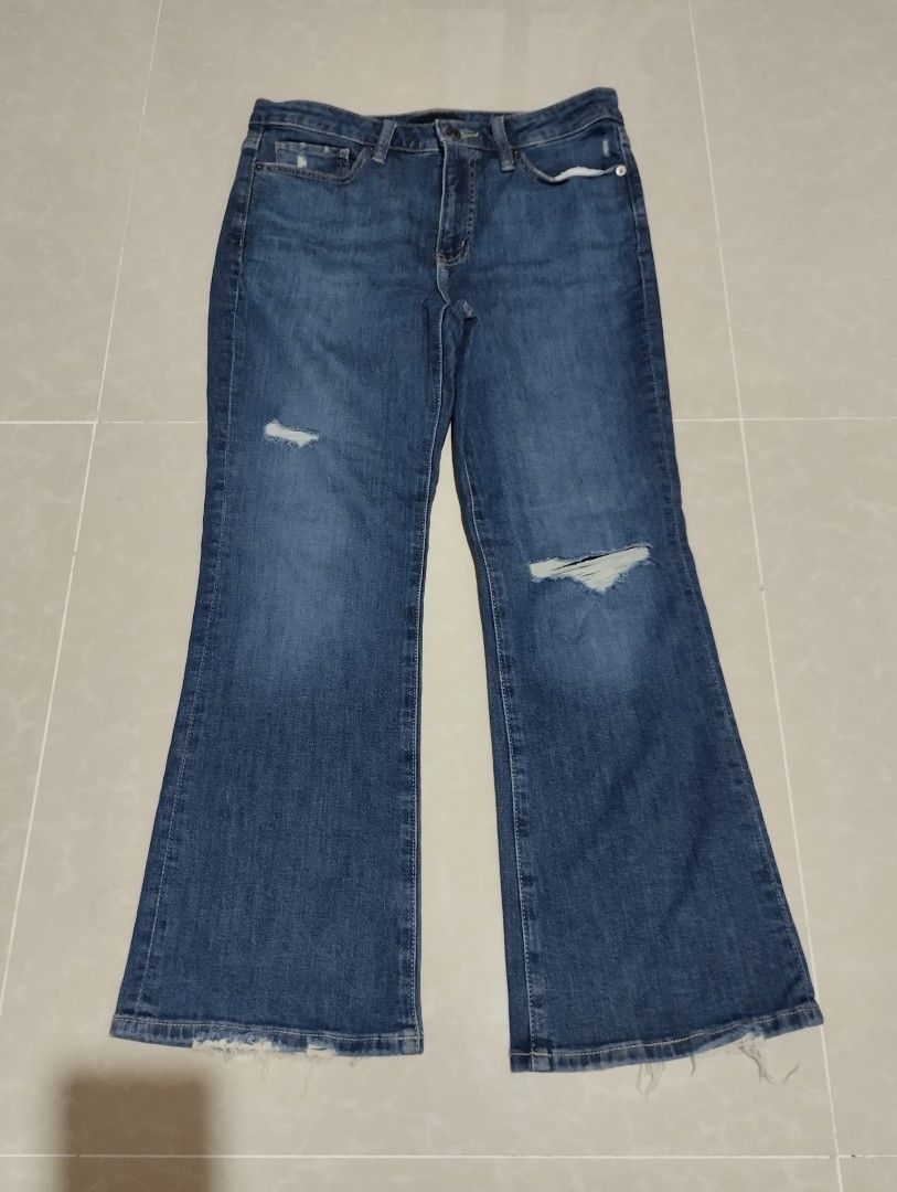 Uniqlo Blue Distressed Flared Jeans (Category: Jeans) located in Mabalacat. Submitted by uniqlover (Listing ID 1467776150, Image 1). Description: - Style: Mid-wash blue denim jeans with a trendy flared leg cut - Details: Distressed knees with a small right thigh rip and larger left knee tear - Hem: Raw, frayed ankle hems for an edgy look - Design: Classic five-pocket styling, belt loops, and front button fly - Fit/Occasion: Casual everyday style,