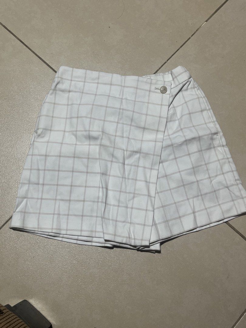 Uniqlo Plaid Wrap Skort Size M (Category: Skirts) located in Manila. Submitted by bleoniz (Listing ID 1467826850, Image 1). Description: Uniqlo plaid skirt-shorts hybrid in size M. White fabric with thin grey checked lines. Wrap front design secured with a single button, elastic back waistband for easy fit. Material is 64 percent polyester, 34 percent rayon, 2 percent spandex. Waist fits 63 to 69 cm, hips fit 88 to 94 cm..