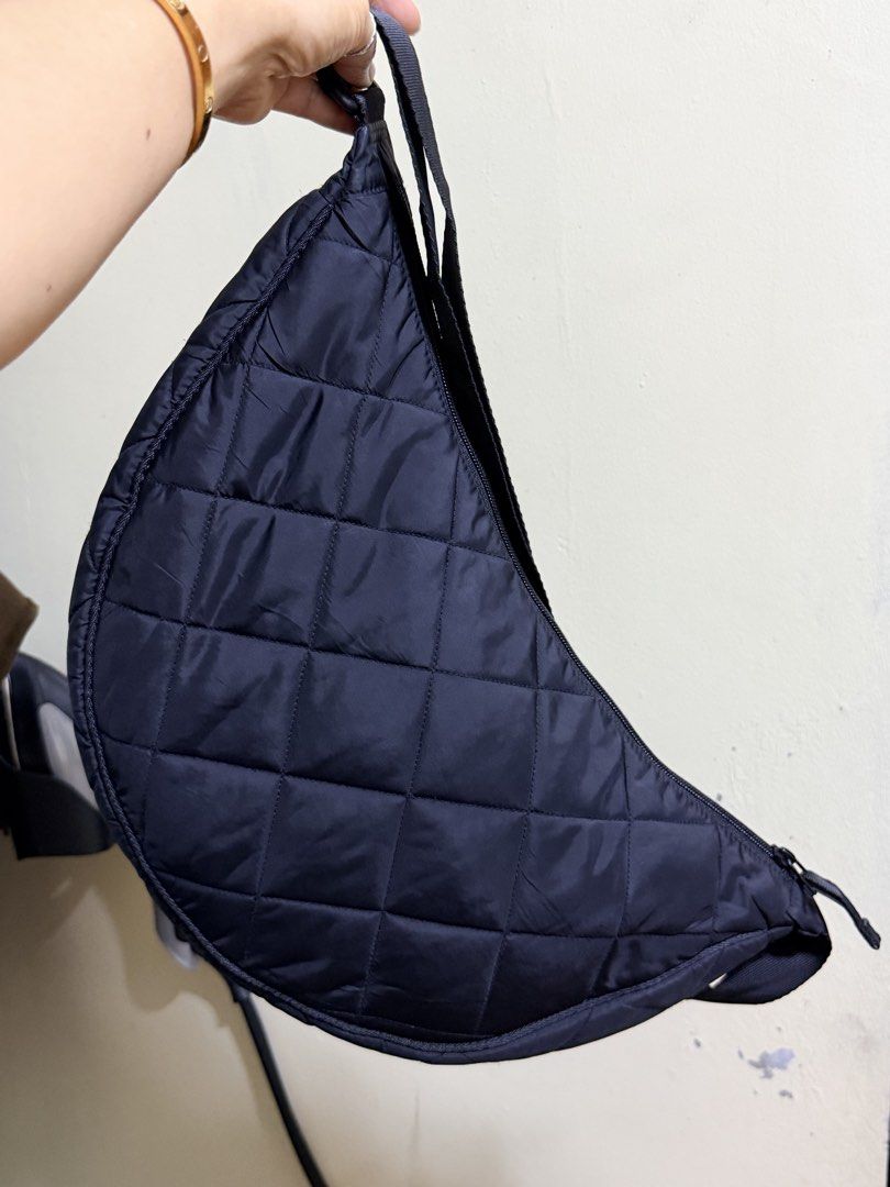 Uniqlo Quilted cresent Shoulder Bag Black (Category: Shoulder Bags) located in Paete. Submitted by skydruemadison (Listing ID 1467719625, Image 1). Description: Black quilted shoulder bag from Uniqlo. Crescent shape with a zipped main compartment and interior pocket. Adjustable strap with buckle. Lightweight nylon material, quilted pattern all over. Spacious inside for daily essentials. Clean interior lining with brand tag attached inside..