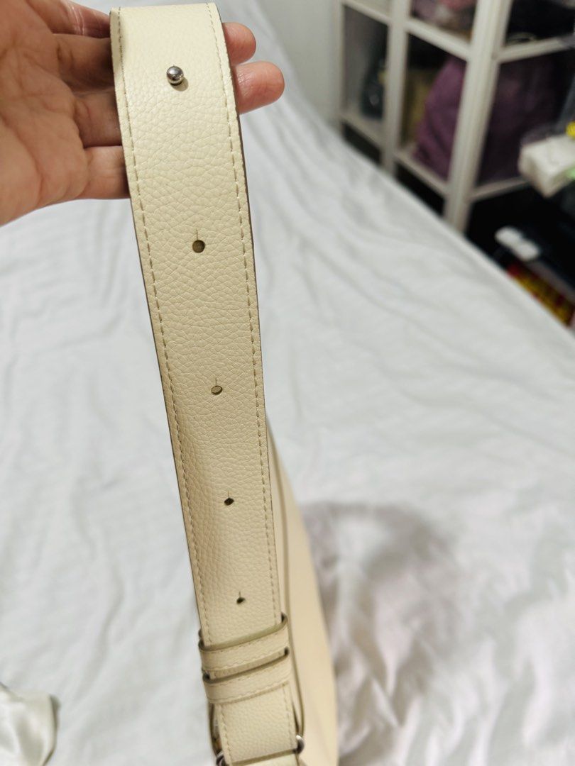 Uniqlo Shoulder bag with adjustable strap- BEIGE (Category: Shoulder Bags) located in Pasig City. Submitted by marizanne04 (Listing ID 1467667349, Image 3). Description: - Color: Off-white - Material: Textured faux leather with matching fabric lining - Design: Structured half-moon shape with clean lines - Hardware: Silver-tone hardware - Closure: Secure zip top closure - Compartments: Two interior slip pockets - Strap: Matching adjustable shoulde