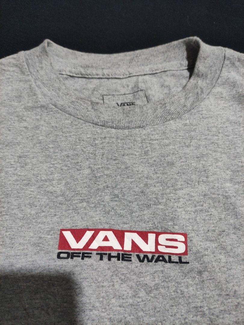 Vans Off The Wall Long Sleeve Tee Grey (Category: Tshirts & Polo Shirts ) located in Binan City. Submitted by mmrl_rmwl00 (Listing ID 1467794704, Image 2). Description: - Brand: Vans -Dimes: 20.5x27 - Color: Grey with red and black graphic details - Material: 100% Cotton, made in Mexico - Design: Red checkered pattern on right sleeve, 'Off The Wall' text on left sleeve, and chest box logo - Fit: Classic crew neck - Care: Machine washable.