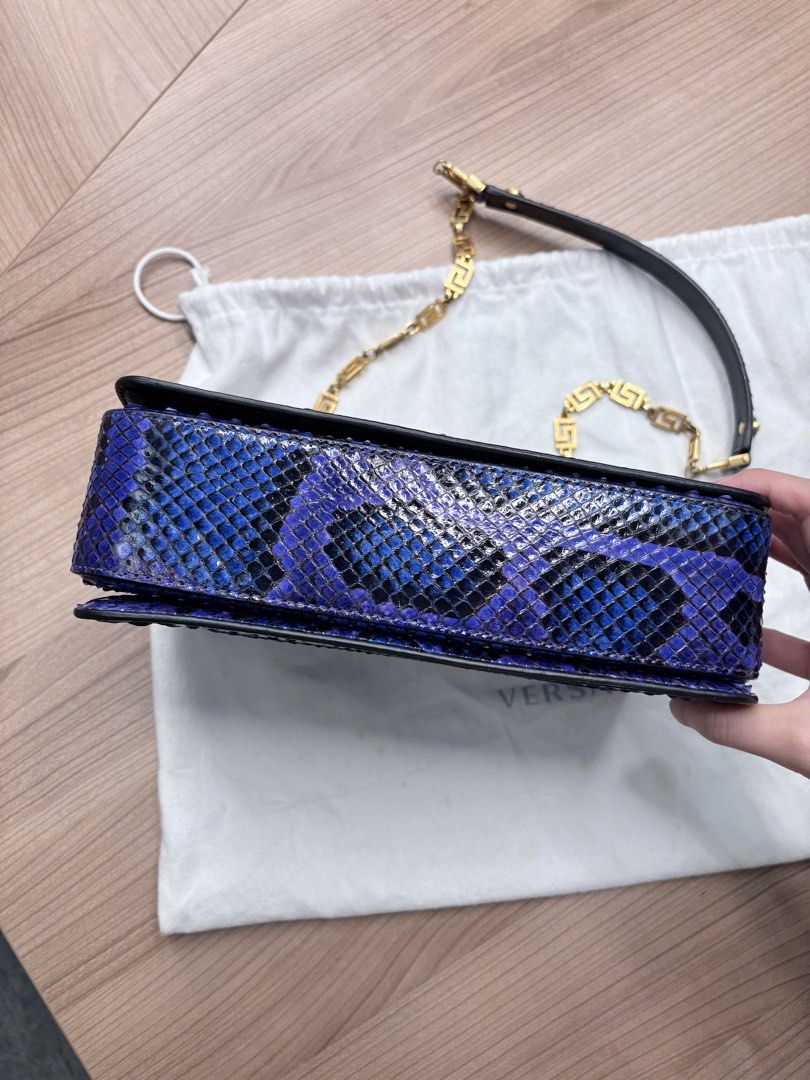 Versace Tribute ( Medium Python Leather) （分類：手袋及銀包）位於 Hong Kong。 由 just.wanna.sell.store 提交（商品編號 1467746909，圖片 3）。簡介： Versace Tribute ( Medium Python Leather) 設計與特色： ✨天然蟒蛇皮打造，保留材質獨特立體質感&豐富鱗片紋理。 ✨精湛工藝染色，呈現神秘奢華的藍紫漸變色調，不同光線下折射出光澤 ✨翻蓋正面飾有圓形金屬扣，中央鑲嵌品牌標誌性的希臘神話「美杜莎頭像」圖案 ✨肩帶採用拼接設計，由質感厚實的金色金屬鏈條構成，並融入了幾何風格的希臘迴紋（Greek Key）圖案 ✨袋身背面設有外置插袋，無需打開翻蓋即可快速收納卡片。 尺寸： 寬：20 - 22 cm 高：13 - 14 cm 深：4 - 5 cm 搭配建議： 精緻的同色系（Monochromatic） 黑色穿搭，與手袋形成對比 奢華小黑裙（適合正式場合及晚間活動） Desig