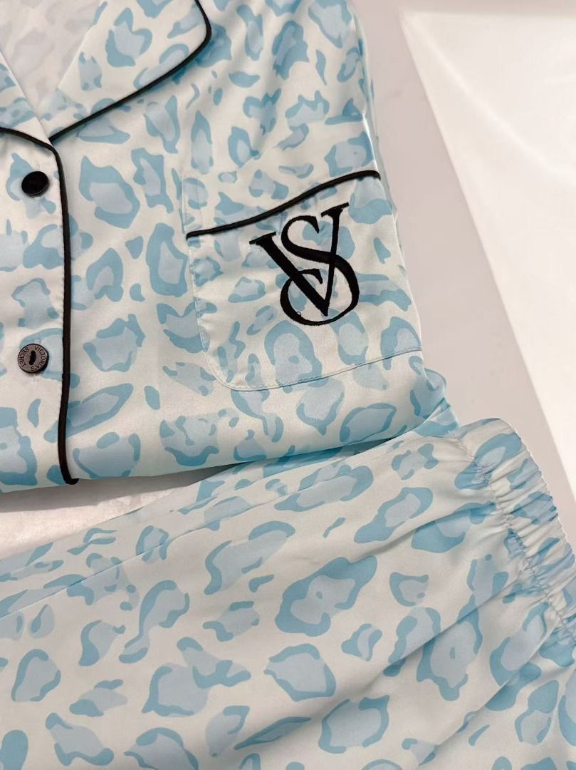 Victoria's Secret Blue Leopard Silk Pyjama Set (Category: Undergarments & Loungewear) located in Quezon City. Submitted by jennabartl92045 (Listing ID 1467657985, Image 2). Description: - Brand: Victoria's Secret - Material: Soft, lightweight, and breathable satin fabric - Design: Chic light blue and white animal print - Top: Short sleeve, button-down, chest pocket with embroidered VS monogram, and piping trim - Bottoms: Long trousers with a comf