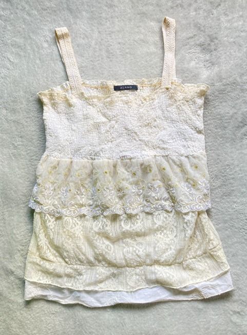 Vintage White Smocked Top (Category: Sleeveless) located in Rizal. Submitted by sheeraay (Listing ID 1467662238, Image 2). Description: - Brand: ALANO - Color: White - Style: Crop top with all-over smocking texture and square neckline - Features: Wide straps, cute ruffle trim, and stretchy crinkled fabric - Fit: Easy to pair with high-waisted jeans, skirts, or shorts.