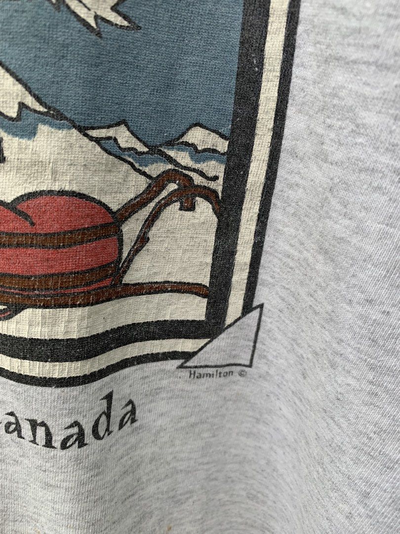 Vintage 1990s Canada parody statement tee (Category: Tshirts & Polo Shirts ) located in Cagayan de Oro. Submitted by premium_thrifts (Listing ID 1467717392, Image 3). Description: Gray colorway. Used condition. Double stitch on both sleeves and hem Fits XL L28" x W23.5" 22.5" (shoulder to shoulder) 8.9" (sleeve length) Issue: crackprint, yellow spot stains on some parts, cut tag, and slight loose collar Add shipping fee (via JRS or J&T).