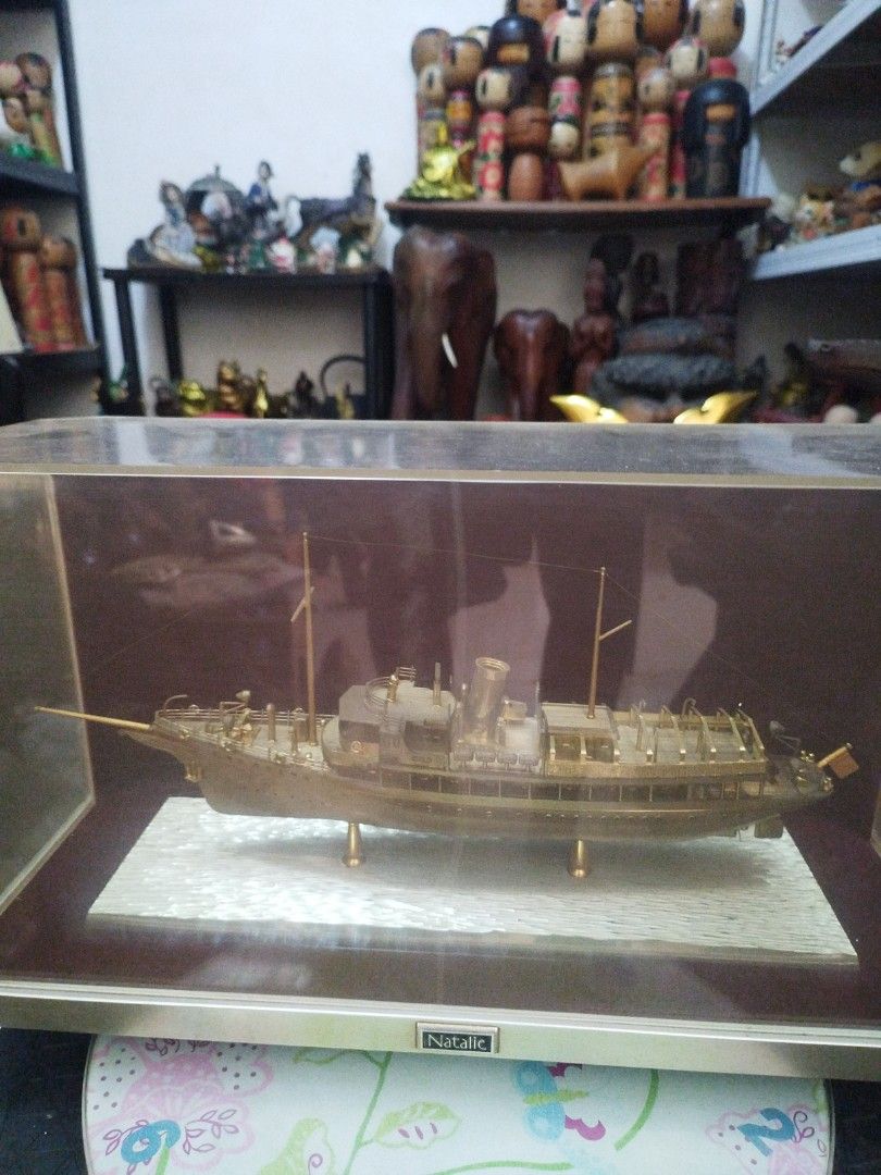 Vintage Natalie ship model (Category: Vintage Collectibles) located in San Rafael. Submitted by jflshoppe1989 (Listing ID 1467658912, Image 3). Description: lenght 16 inches height 9 inches Key Details • Subject: A detailed metallic or gold-plated-finish miniature model of the ship Natalie. • Presentation: Enclosed in a clear acrylic or plastic display case with a dark red/brown base and a small "Natalie" placard on the front.