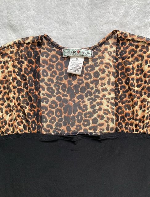 Vintage Suzie Leopard Print Black Top (Category: Longsleeves) located in Rizal. Submitted by sheeraay (Listing ID 1467661898, Image 2). Description: - Brand: Vintage Suzie - Size: M (tag attached) - Design: Leopard print sheer top with a solid black bottom section - Neckline: Scoop neck - Material: Soft and stretchy black fabric.
