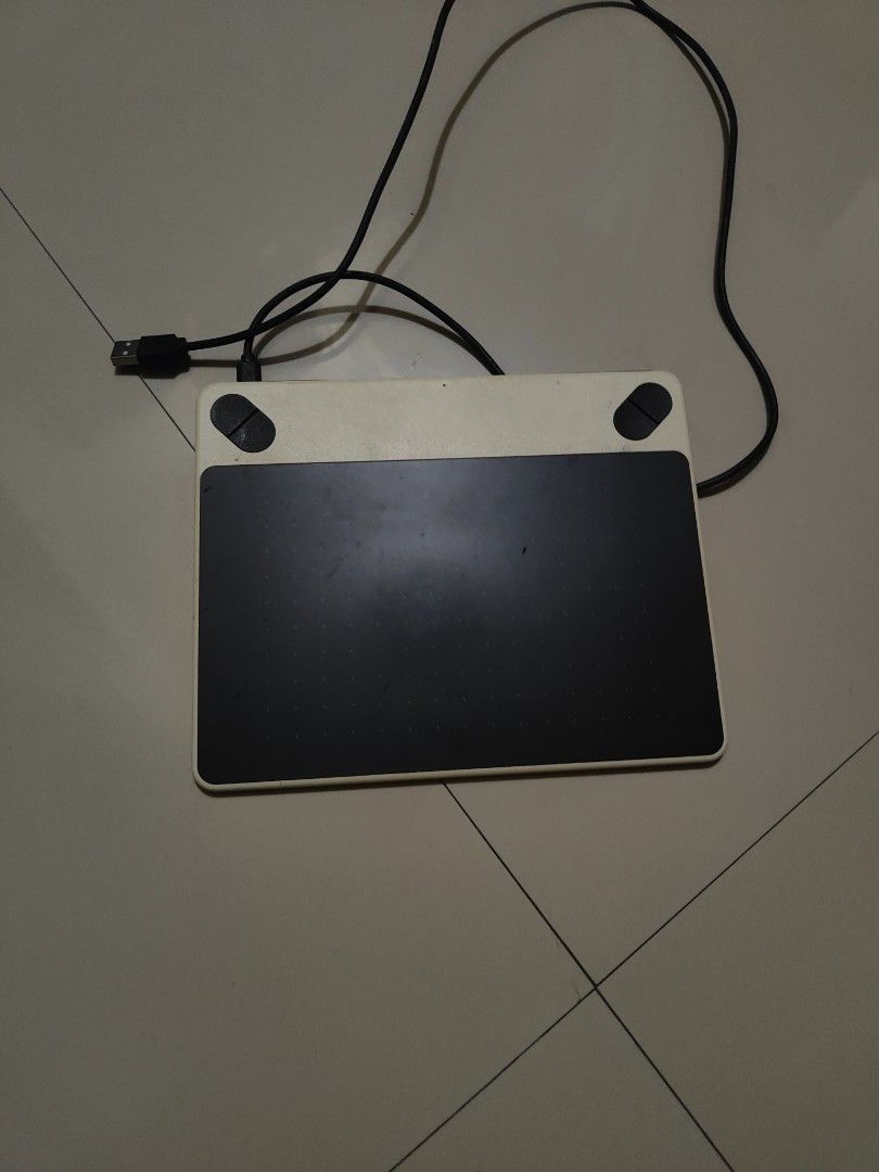 Wacom Drawing Tablet with USB Cable (Category: Laptops & Notebooks) located in Manila. Submitted by jojemar890 (Listing ID 1467699755, Image 3). Description: - Model: Wacom Drawing Tablet (Black & White) - Connectivity: Attached USB cable with standard connector for direct plug-and-play - Condition: Active drawing surface shows minor signs of use - Features: Two physical buttons at the top for quick access - Stability: Equipped with rubber feet o