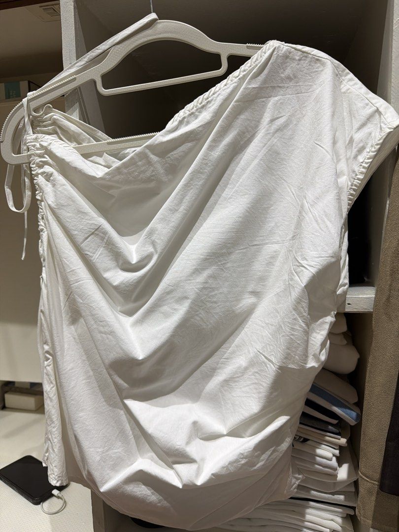 White Asymmetric Drape Top with Ruched Details (Category: Sleeveless) located in Batangas. Submitted by luxuryinmyclowset (Listing ID 1467701578, Image 2). Description: - Color: White - Style: Sleeveless top with draped neckline - Details: Side ruching and adjustable drawstring tie on one shoulder - Material: Soft, lightweight cotton-blend - Versatility: Perfect for casual wear, easy to dress up with a skirt or down with jeans.