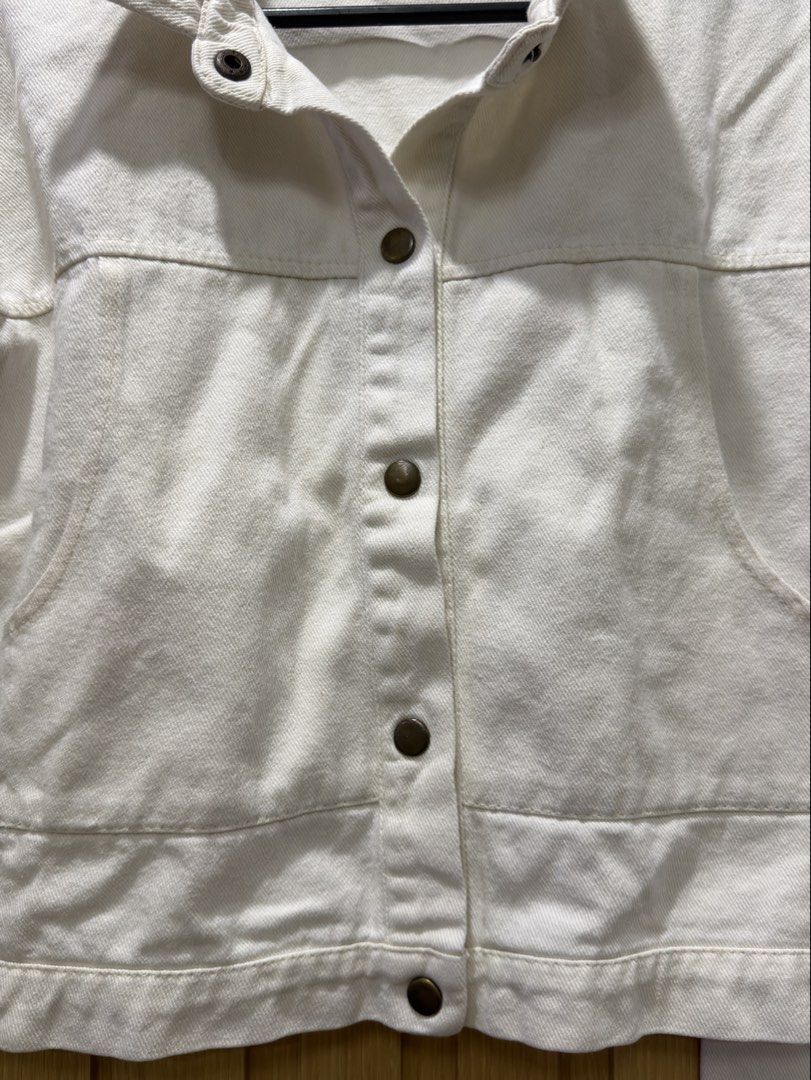 White denim jacket with front pockets and buttons (Category: Coats, Jackets and Outerwear) located in Bacoor. Submitted by preloved_with_love_ (Listing ID 1467610360, Image 3). Description: - Style: Trendy cropped white denim jacket - Material: Structured, high-quality cotton - Details: Classic collar, dark metallic button-down front, button cuffs - Pockets: Two large front utility pockets near the hem - Fit & Versatility: Easy everyday layering 