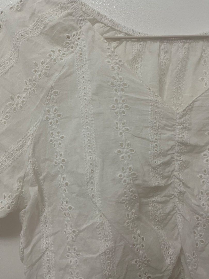 White Eyelet Embroidered Crop Top Blouse (Category: Blouses) located in Batangas. Submitted by povofkbscloset (Listing ID 1467670163, Image 2). Description: - Color: White - Style: Short-sleeve crop top with V-neck and ruched front - Details: Allover eyelet embroidery, floral patterns, and trendy puff sleeves - Fabric: Light, airy, and breathable for warm weather - Condition: Brand new/Excellent - Perfect for: Casual lakad, beach trips, or OOTDs.
