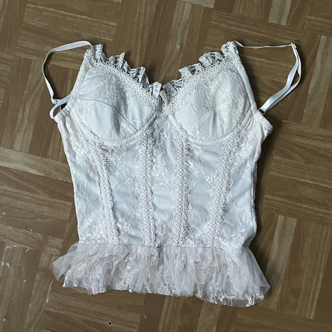 White Lace Corset Top with Ruffle Hem (Category: Sleeveless) located in Santa Rosa. Submitted by peachilee (Listing ID 1467636212, Image 1). Description: - Style: White lace corset top with sheer floral pattern - Details: Structured bustier cups, adjustable shoulder straps, and ruffle mesh trim - Closure: Hook-and-eye closure down the back - Condition: Gentle wear with minor faint discoloration near the bottom hem on the inside lining (unnoticeab
