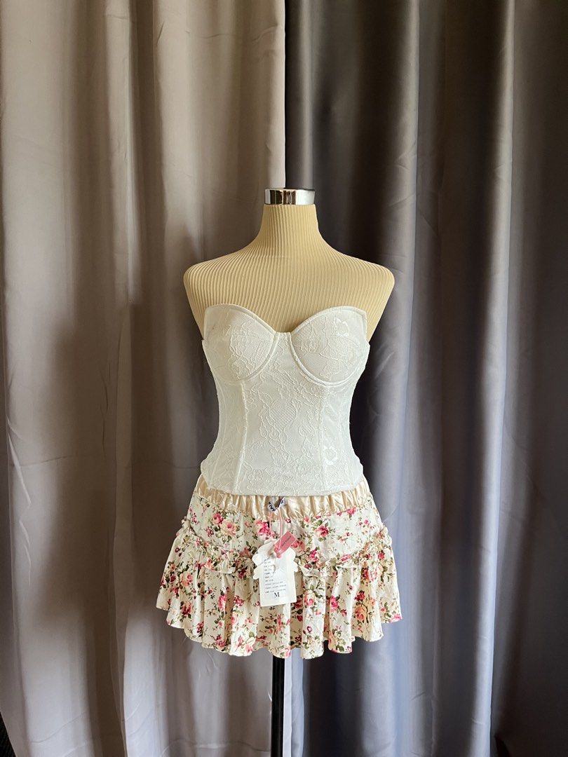 Lioness White Lace Strapless Corset Bustier Top (Category: Sleeveless) located in Cagayan de Oro. Submitted by curated_closetph (Listing ID 1467765713, Image 1). Description: — Size : XS - S — Color: White — Sheer floral lace overlay for a romantic look — Strapless sweetheart neckline — Molded underwire cups for support and shaping — Internal boning for a cinched waist — Adjustable multi-row hook-and-eye back closure — Straight hemline for versat