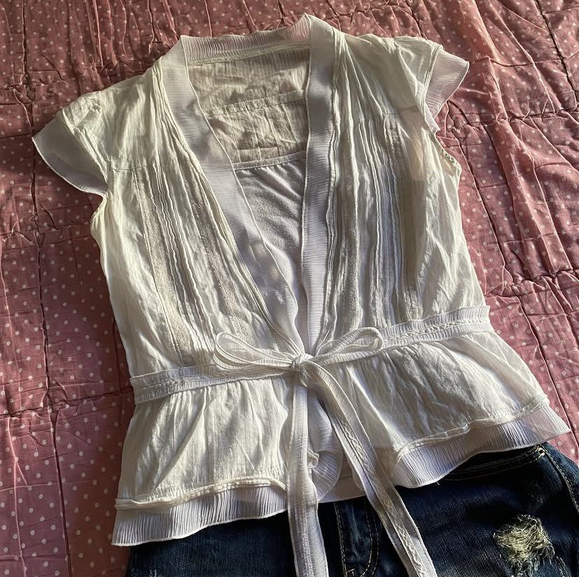 White layered short sleeve top with tie front (Category: Blouses) located in Dasmarinas. Submitted by lihyienne (Listing ID 1467688336, Image 3). Description: bought this from ig thrift shops for 350 pesos (pic came from their acc) sadly it does not fit me :(( can provide proof of transaction bought this for 350 + sf - small - med.