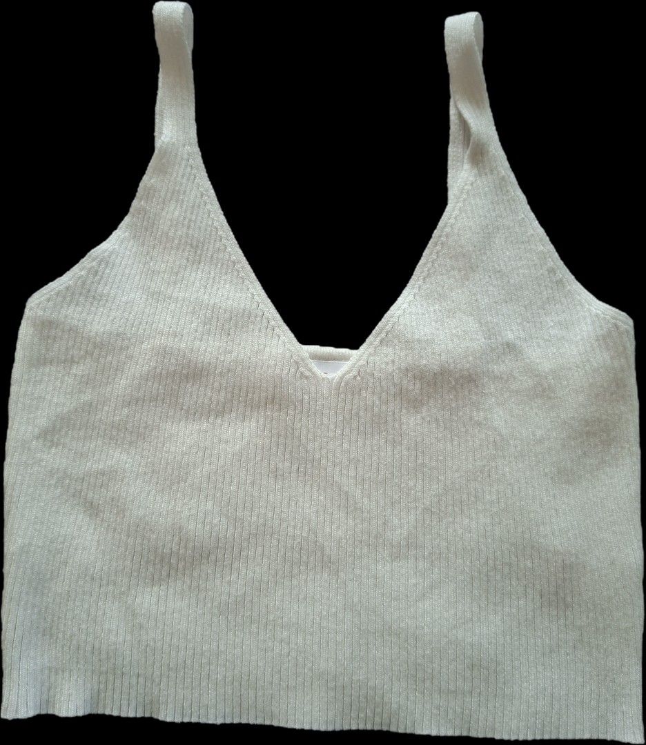 White Ribbed V-Neck Crop Tank Top (Category: Sleeveless) located in Las Pinas. Submitted by melsv (Listing ID 1467695204, Image 1). Description: - Color: White - Style: Deep V-neckline with thick straps - Fit: Cropped length, sits at the waist, stretchy knit material - Condition: Clean, no stains or damage - Versatility: Great basic piece for layering or wearing solo.