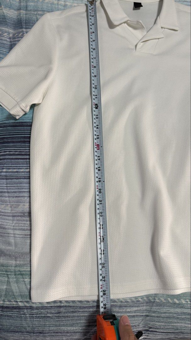 White Short Sleeve Polo Shirt (Category: Tshirts & Polo Shirts ) located in Quezon City. Submitted by kobeeeee_12 (Listing ID 1467513817, Image 3). Description: - Color: White - Style: Minimalist streetwear - Design: Textured knit pattern with a spread collar and open placket - Fit: Relaxed fit through the body - Fabric: Breathable, ideal for warm weather.