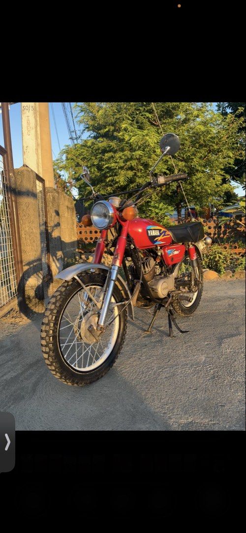 Yamaha RS100 Motorcycle with Sidecar (Category: Motorbikes for Sale) located in Manila. Submitted by rusell_inmotion (Listing ID 1467824764, Image 2). Description: Red Yamaha RS100 motorcycle equipped with a black metal cargo sidecar attached to the right side. Knobby tires installed front and rear. Chrome handlebars fitted with round rearview mirrors. Single bench seat upholstered in black. Chrome front fender and exhaust pipe. Standard round he
