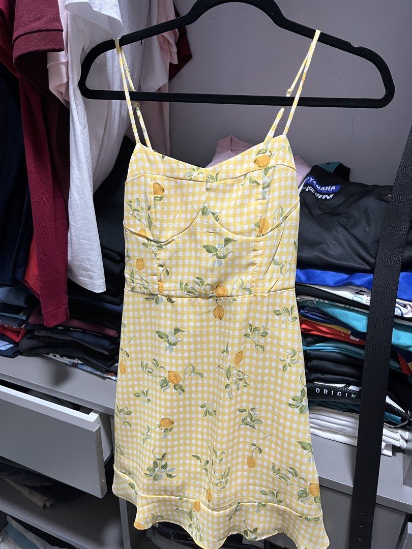Yellow gingham lemon print spaghetti strap mini dress (Category: Dresses) located in Valenzuela. Submitted by tanshielam82073 (Listing ID 1467838829, Image 1). Description: - Pattern/Design: Yellow and white gingham with a vibrant lemon and green leaf print - Style: Sleeveless mini dress with thin adjustable spaghetti straps and a playful ruffle hem - Fit & Details: Structured bustier-style cups with a flattering sweetheart neckline and a secure 