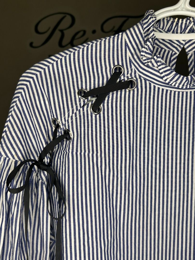 Zara Basic Blue White Striped Blouse Size M (Category: Blouses) located in Taguig. Submitted by re.wear.mnl (Listing ID 1467709584, Image 3). Description: - Brand: Zara Basic - Size: M - Material: 100% cotton - Design: Blue and white vertical stripes with black ribbon lace-up shoulder details - Neckline: High ruffled neck with back keyhole button closure - Sleeves: Long balloon sleeves with tie cuffs - Condition: Excellent pre-loved condition (re
