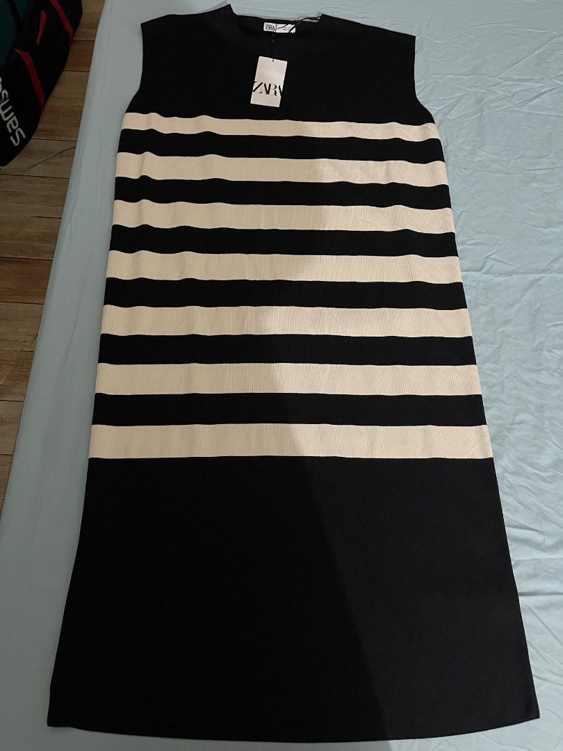 Zara Striped Knit Dress (Category: Dresses) located in Subic. Submitted by anything_lovely_under_the_sun (Listing ID 1467837719, Image 1). Description: - Brand: Zara - Condition: Brand new with original tags attached - Size: XL - Color/Design: Black and white striped upper body with a solid black skirt - Style: Sleeveless knit midi dress - Material: Comfortable fabric with good stretch - Origin: Made in Turkey - Versatility: Ideal for casual outi