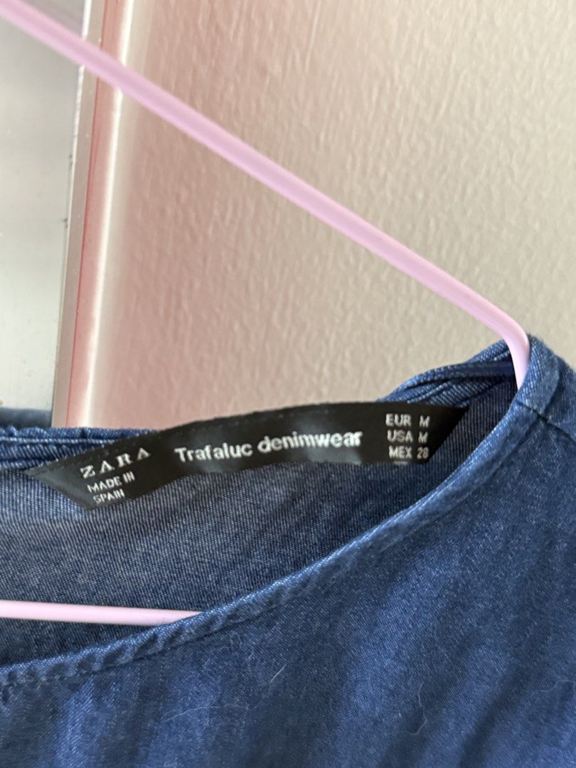 Zara Trafaluc Denimwear Blue Blouse Size M (Category: Blouses) located in Mandaluyong City. Submitted by declutteringmylife101 (Listing ID 1467632521, Image 2). Description: - Brand: Zara Trafaluc - Item: Lightweight denimwear top - Color: Blue - Size: Medium (EUR M, USA M, MEX 28) - Details: Long sleeves with ribbed cuffs, sleeve pocket, striped ribbed hem, crew neckline, and back button closure - Condition: Excellent / Ready to wear - Perfect f