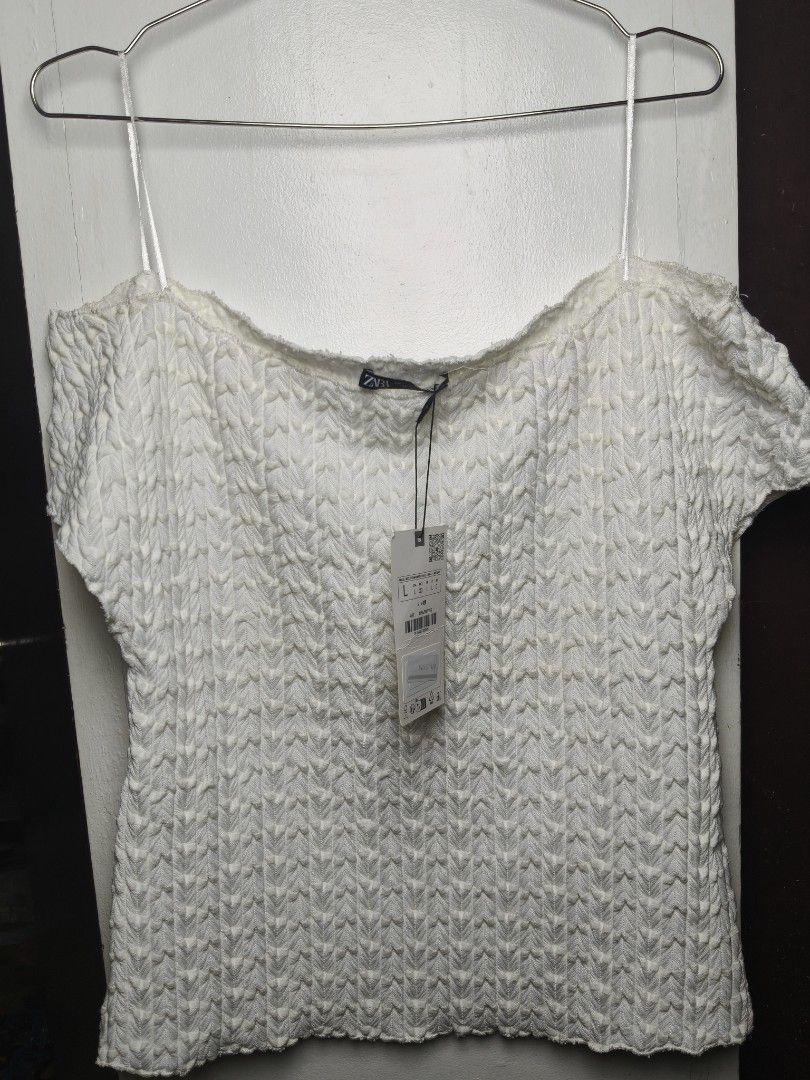 Zara White Off-Shoulder Textured Top (Category: Blouses) located in Taguig. Submitted by ashie_clothing (Listing ID 1467835925, Image 2). Description: - Brand: Zara - Style: Off-shoulder top with short sleeves and raw edges - Color: White - Size: L - Condition: Brand new with original tags attached, never worn - Material: Textured fabric.