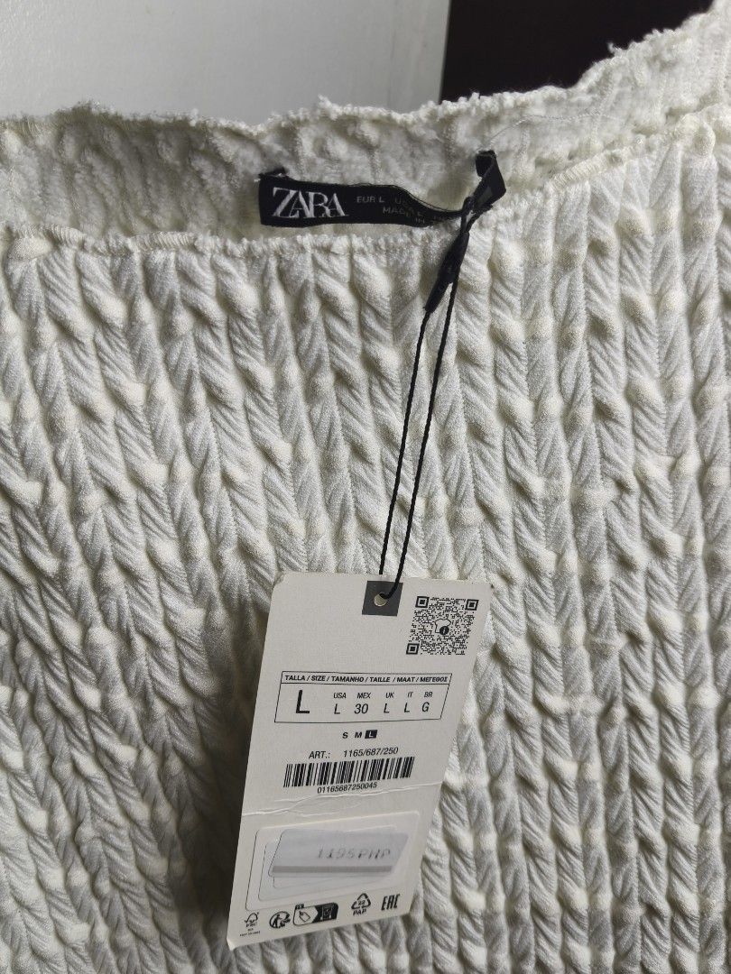 Zara White Off-Shoulder Textured Top (Category: Blouses) located in Taguig. Submitted by ashie_clothing (Listing ID 1467835925, Image 3). Description: - Brand: Zara - Style: Off-shoulder top with short sleeves and raw edges - Color: White - Size: L - Condition: Brand new with original tags attached, never worn - Material: Textured fabric.
