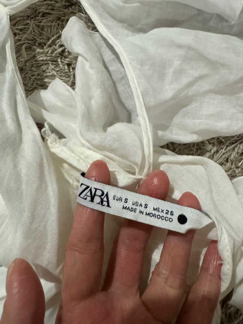 Zara White Ruffle Halter Top (Category: Sleeveless) located in Caloocan City. Submitted by newcrystal_3b43ba (Listing ID 1467739471, Image 2). Description: - Brand: Zara - Size: S (fits true to size) - Color: White - Design: Dramatic ruffles, open back, and self-tie neck/back straps - Material: Lightweight and breezy - Origin: Made in Morocco - Condition: Great statement piece for warm weather or night outings.