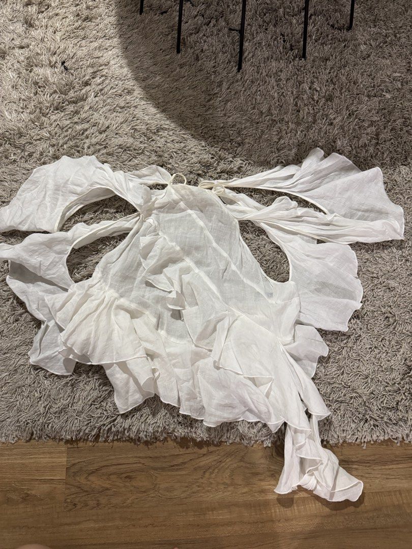 Zara White Ruffle Halter Top (Category: Sleeveless) located in Caloocan City. Submitted by newcrystal_3b43ba (Listing ID 1467739471, Image 1). Description: - Brand: Zara - Size: S (fits true to size) - Color: White - Design: Dramatic ruffles, open back, and self-tie neck/back straps - Material: Lightweight and breezy - Origin: Made in Morocco - Condition: Great statement piece for warm weather or night outings.